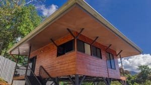 Beautiful elevated home with wooden exterior and large windows in Dominical.