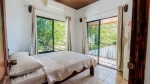 Bright bedroom with large windows and balcony in Dominical Costa Rica.