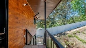 View of a wooden house exterior with stairs and lush greenery in Dominical, Costa Rica.