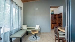 Interior of a Costa Rican home with a sofa, wooden table, and dining area.