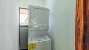 Laundry room with stacked washer and dryer in a small space.