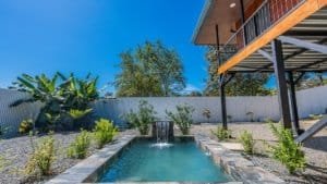 Beautiful backyard with pool, plants, and modern house in Dominical.
