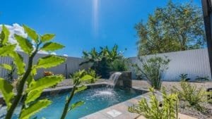 Scenic backyard with pool, waterfall, and lush greenery in Dominical.
