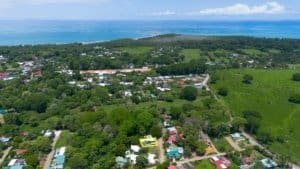 Aerial view of Dominical coastal area with lush greenery and ocean in background.