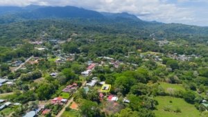 Aerial view of Uvita town surrounded by green mountains and forests.