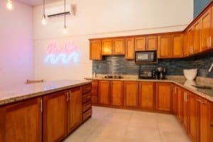 Modern kitchen with wooden cabinets and black backsplash in Uvita area.