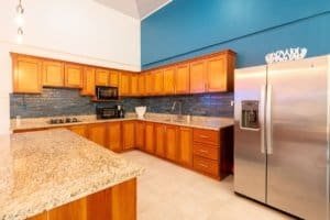 Modern kitchen with wooden cabinets, granite countertops, and stainless steel appliances in Uvita.