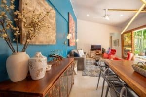 Modern living room with vibrant blue wall, artwork, and cozy seating in Uvita.