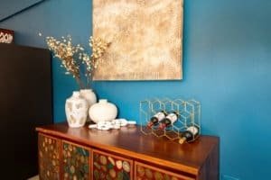 Decorative vases and wine bottles on a wooden sideboard in a modern home.