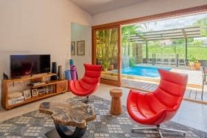 Modern living room with large glass doors overlooking pool in Uvita.