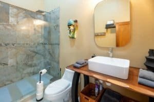Modern bathroom with walk-in shower and stylish sink in Uvita area.