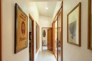 Bright hallway with artwork and open doors in Costa Rican house.
