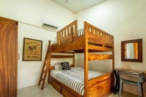 Cozy bedroom with wooden bunk bed and modern decor in Uvita, Costa Rica.