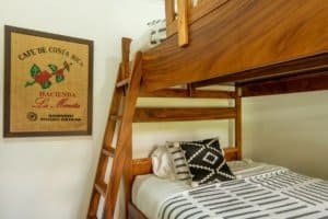 Interior of a cozy bedroom with a wooden bunk bed and decorative pillows in Uvita.