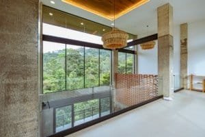 Luxury modern house interior with large glass windows and ocean view.