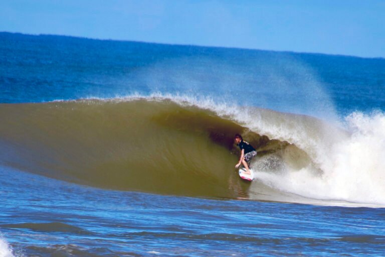 young man surfing barrel at dominical beach