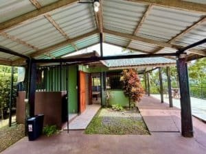 Eco-friendly cabin in Dominical with ocean and valley views, lush greenery, and outdoor deck.