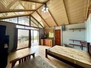 Interior of a Costa Rican cabin with wooden ceiling and ocean view.