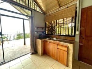 Interior view of a small kitchen with wooden cabinets and a balcony door.