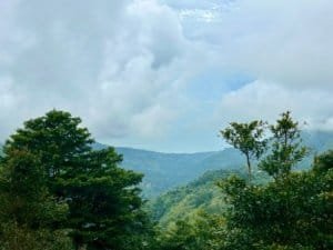 Scenic view of lush green mountains and cloudy sky in Dominical, Costa Rica.