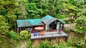 Cabin with ocean and valley view in lush Costa Rican forest.