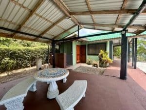 Costa Rican cabin with outdoor seating and lush surroundings.