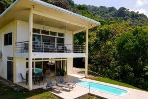 Contemporary Costa Rican home with pool, balcony, and lush green surroundings.