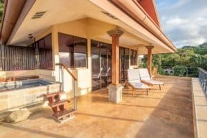Balinese-style home balcony with ocean view and lounge chairs in Dominical.