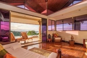 Interior of a Balinese-style home with ocean view, wooden floors, and modern decor.