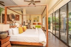 Elegant bedroom with ocean view, Balinese-inspired decor, and modern amenities.