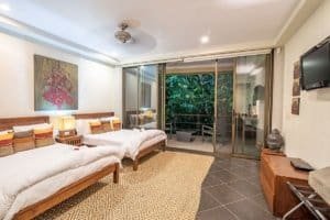 Spacious bedroom with ocean view, Balinese-inspired decor, and modern amenities.