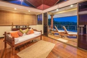 Elegant living room with ocean view, wooden furniture, and outdoor balcony.