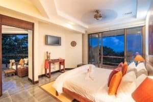 Spacious bedroom with ocean view, modern decor, and balcony in Costa Rica.