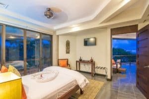 Spacious bedroom with ocean view, balcony, and modern decor in Dominical.