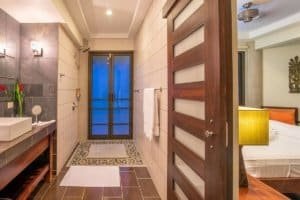 Modern bathroom with ocean view, Balinese-inspired decor, and wooden accents.