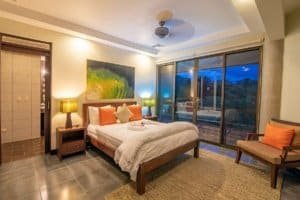 Elegant bedroom with ocean view, modern decor, and balcony in Dominical.