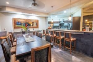 Elegant dining room with ocean view, modern decor, and wooden furniture.