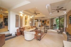 Spacious modern living room with ocean view and tropical decor.