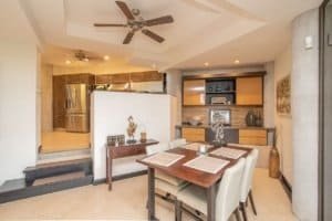 Elegant dining area with ocean view, modern decor, and open kitchen in Costa Rica.