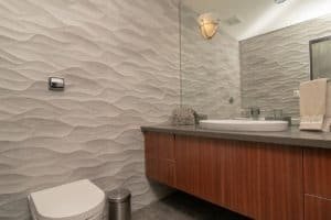 Contemporary bathroom with textured wall, sink, and mirror in Costa Rica.
