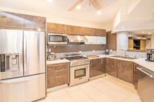 Contemporary kitchen with stainless steel appliances and brown cabinets in Dominical.