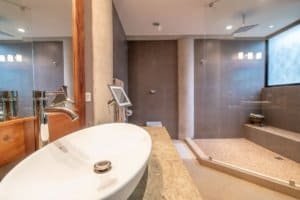 Modern bathroom with ocean view, walk-in shower, and freestanding tub in Dominical.