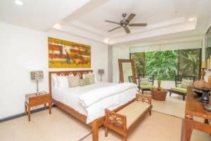 Spacious bedroom with ocean view, Balinese-inspired decor, and modern amenities.