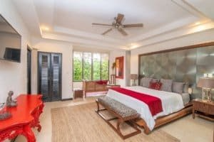 Spacious bedroom with ocean view, modern decor, and Balinese-inspired design elements.