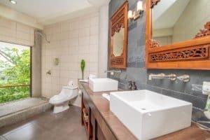 Modern bathroom with double sinks, ocean view, and tropical decor in Dominical.