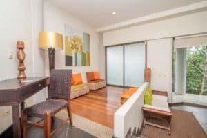 Spacious living room with ocean view, modern decor, and wooden flooring.