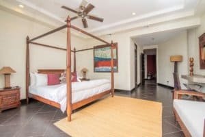 Spacious bedroom with canopy bed, modern decor, and ocean view in Costa Rica.