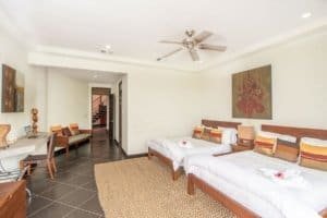 Spacious bedroom with two beds, ocean view, and modern decor in Dominical.