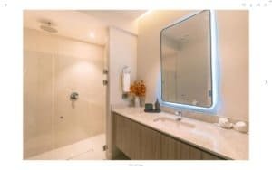 Modern bathroom with large mirror, vanity, and walk-in shower in Dominical.