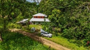 Fully renovated Costa Rican-style home surrounded by lush greenery and streams.